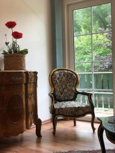 una camera con una sedia, un tavolo e una finestra di Pension Hühnermühle a Volkerode