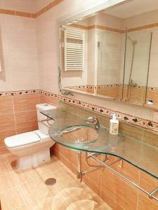 ein Badezimmer mit einem Waschbecken, einem WC und einem Spiegel in der Unterkunft Apartamento con vistas al mar, Costa da Morte in Cee