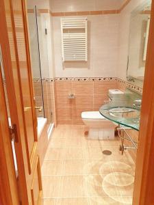 ein Bad mit einem Waschbecken, einem WC und einem Fenster in der Unterkunft Apartamento con vistas al mar, Costa da Morte in Cee