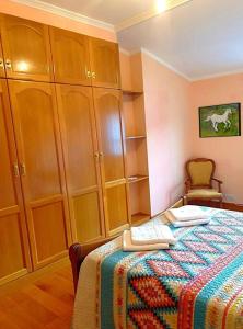 ein Schlafzimmer mit einem Bett und einigen Holzschränken in der Unterkunft Apartamento con vistas al mar, Costa da Morte in Cee