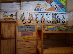 a room with two bunk beds and a wall with signs at Casa surf arrels in Montañita