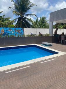 a swimming pool in a resort with a palm tree at Apartamento Temporada Praias Litoral sul João Pessoa in João Pessoa