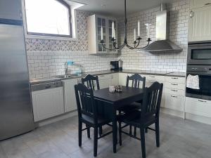 uma cozinha com uma mesa preta e cadeiras em Utterbyn/Sirsjön 