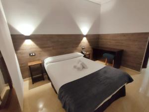 a bedroom with a large white bed and wooden walls at Hotel Artxanda Bilbao in Bilbao