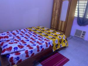 a bedroom with a bed with a comforter on it at Appartement et Chambres in Bamako