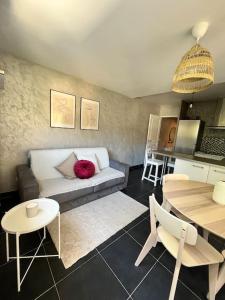 a living room with a couch and a table at Charmant 2 pièces proche Monaco - Parking privé in Menton