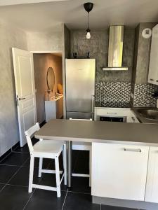 a kitchen with a table and a refrigerator at Charmant 2 pièces proche Monaco - Parking privé in Menton
