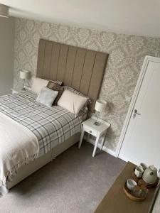 1 dormitorio con 1 cama y 1 mesa con 2 lámparas en Woodland House B & B, en Wimborne Minster