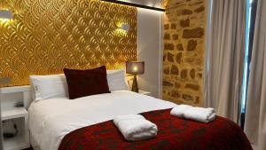 Un dormitorio con una cama con dos toallas encima. en HOTEL FUENTE REDONDA LUXURY, en Úbeda