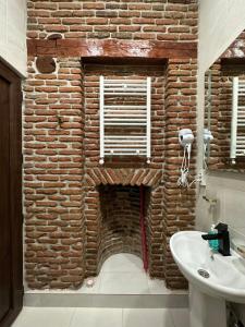 ein Badezimmer mit einer Backsteinwand und einem Waschbecken in der Unterkunft Apartment #5 Old Tbilisi in Tbilisi City