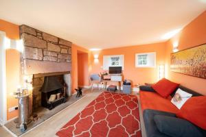 a living room with a couch and a fireplace at Blindwelleyes Cottage in Blairgowrie