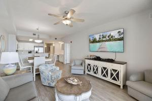 a living room with a couch and a dining room at Modern Beach Vibe with a Breathtaking View - Stunning Pool - Pier Park in Panama City Beach