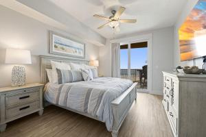 a bedroom with a bed and a ceiling fan at Modern Beach Vibe with a Breathtaking View - Stunning Pool - Pier Park in Panama City Beach