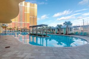 ein Schwimmbad in einem Resort mit einem Gebäude in der Unterkunft Modern Beach Vibe with a Breathtaking View - Stunning Pool - Pier Park in Panama City Beach