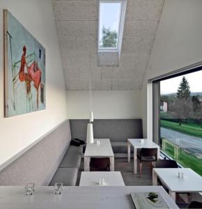 a dining room with tables and a large window at LOGIS125 I Barbara Hofmann in Gamlitz