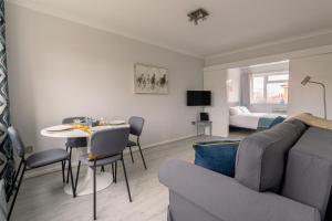 a living room with a couch and a table at Racecourse Revelation! Free parking in Newbury