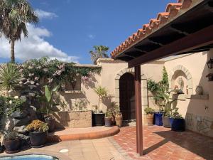 a house with a courtyard with potted plants at Casa Paraiso Villa Tenerife, stunning family bungalow with totally secluded pool area, wheelchair friendly in San Miguel de Abona