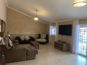 a living room with a couch and a flat screen tv at Casa Paraiso Villa Tenerife, stunning family bungalow with totally secluded pool area, wheelchair friendly in San Miguel de Abona