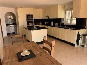 a large kitchen with a wooden table and a dining room at Casa Paraiso Villa Tenerife, stunning family bungalow with totally secluded pool area, wheelchair friendly in San Miguel de Abona