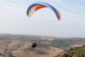 una persona montando un paracaídas en el aire en Hostal El Mirador, en Vejer de la Frontera