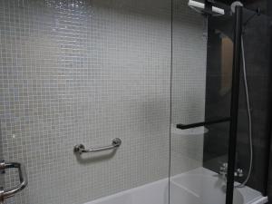 een badkamer met een douche en een glazen deur bij casalonne in Tavira