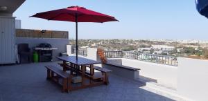 un tavolo da picnic con ombrellone su un balcone di Penthouse 2 a Marsaskala