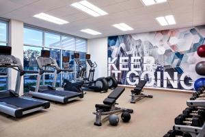 une salle de sport avec plusieurs tapis de course et une fresque murale. dans l'établissement SpringHill Suites by Marriott Cincinnati Mason, à Mason