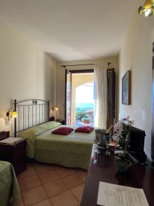 a bedroom with a bed and a large window at Kalura B&B in San Vito lo Capo