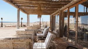 un edificio con sedie e tavoli sulla spiaggia di Desert Sands Dakhla a Dakhla