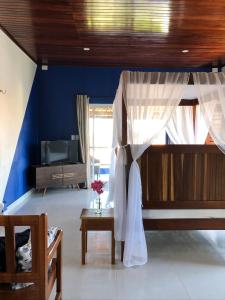 1 dormitorio con 1 cama con cortina y mesa en Flat Meier, en Canoa Quebrada
