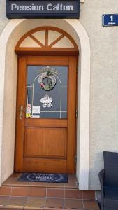 drewniane drzwi z znakiem na górze w obiekcie Frühstückspension Elena Nicoleta Caltun w mieście Fischamend