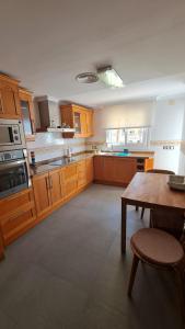 a large kitchen with wooden cabinets and a wooden table at Moraira Beach 1 in Moraira