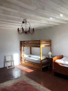 sypialnia z 2 łóżkami piętrowymi i żyrandolem w obiekcie Sainte-Suzanne gîte de LA FERME calme et tranquille w mieście Les Baux-de-Breteuil
