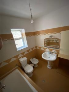 a bathroom with a toilet and a sink at Elti Apartment in Sarandë +75 photos