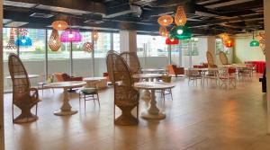 un restaurante con mesas, sillas y luces coloridas en Luxxe interior design condo @ Novotel Suites Manila - Acqua, en Manila