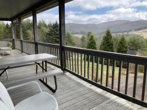 a screened in porch with a table and chairs at The Place on the Blue Ridge Parkway in Ore Knob