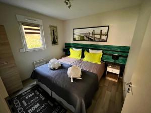 1 dormitorio con 2 camas con almohadas amarillas en Lodge spa privatif Sylvestre, séjour zen, en Meisenthal