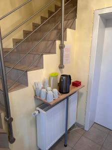 a kitchen with a counter with cups and a staircase at Haus Hotel & Pension am Birnengarten in Magdeburg