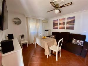 a living room with a table and a couch at Casa 3 habitaciones y Piscina de temporada compartida - - Jacuzzi Spa No incluido -- By TrassierraRooms in Córdoba