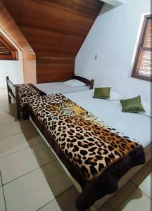 a leopard print bed in a room at Excelente Apto a 2 km CENTRINHO TURÍSTICO in Campos do Jordão