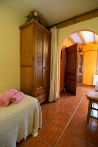 a bedroom with a bed and a cabinet and a tile floor at El Refugio de la Esquina in Mata de Quintanar