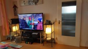 a flat screen tv in a living room with two lamps at Beliebte Unterkunft 60qm in Neuss zwischen Düsseldorf & Köln in Neuss