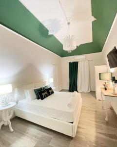 a bedroom with a white bed and a green ceiling at Domus Federiciana in Castellammare del Golfo