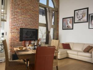 ein Wohnzimmer mit einem Tisch und einer Ziegelwand in der Unterkunft Loft au coeur du Vieux-Québec in Québec