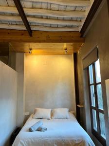 ein Schlafzimmer mit einem weißen Bett und einer Holzdecke in der Unterkunft Suite Catedral in Granada