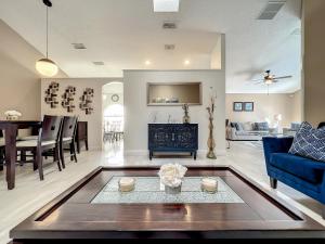 - un salon avec un canapé bleu et une table dans l'établissement Gorgeous Pool Home Near Disney - 2024 specials!, à Davenport