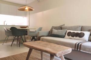 a living room with a couch and a table at Appartement 2 chambres COULEUR DUNE, piscine, parking gratuit in Le Touquet-Paris-Plage