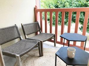 two chairs and a table on a porch at Appartement 2 chambres COULEUR DUNE, piscine, parking gratuit in Le Touquet-Paris-Plage