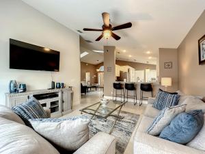 a living room with a couch and a ceiling fan at Gorgeous Pool Home Near Disney - 2024 specials! in Davenport