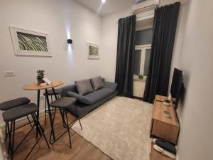 een woonkamer met een bank en een tafel bij Studio apartman Luka in Zagreb